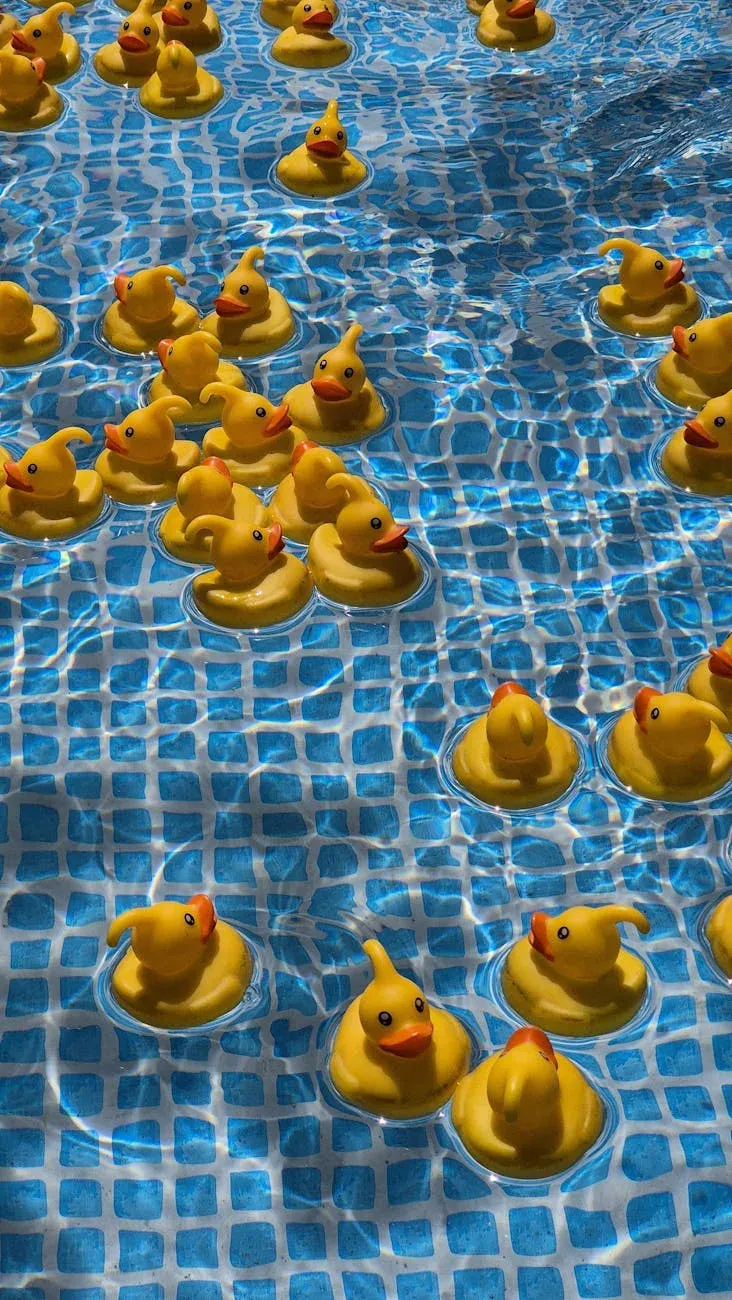 Patos de borracha amarelos flutuando em uma piscina azul-clara, criando um cenário lúdico e vibrante.