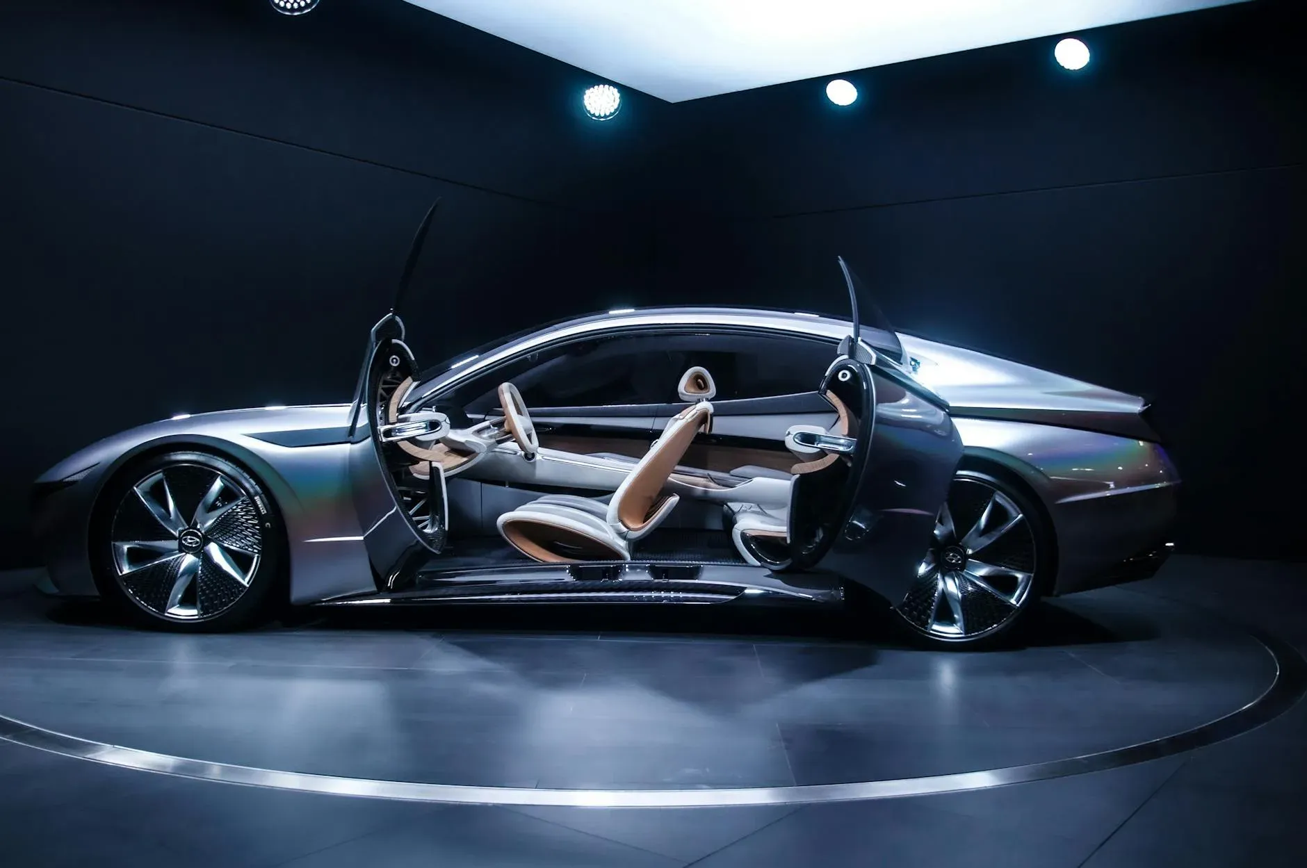 Carro conceito elegante e moderno exposto em ambiente interno com portas tipo tesoura abertas, destacando seu design futurista.