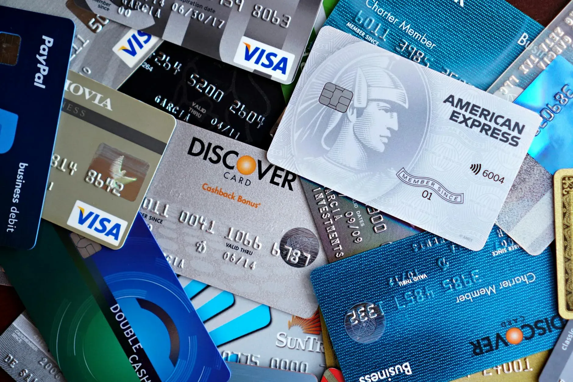 Imagem em close-up de vários cartões de crédito, incluindo Visa, Mastercard e American Express.
