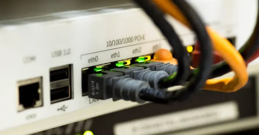 Portas LAN de um roteador com cabos de rede conectados e luzes de atividade acesas